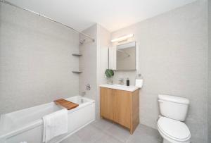 a bathroom with a toilet and a tub and a sink at Cozy apt with great city view in Union City