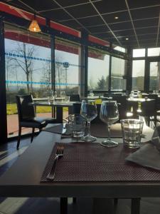 una mesa en un restaurante con copas de vino. en Fasthotel Montmarault en Montmarault