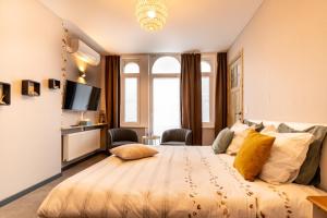 een slaapkamer met een groot bed met gele kussens bij 't Zandmanneke in Oostende