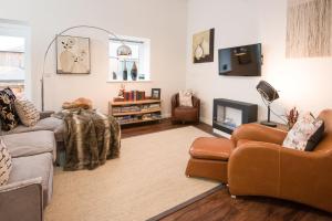 a living room with two couches and a tv at Stables in Melrose