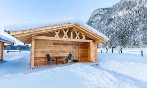 a cabin with a table and chairs in the snow at Austria Parks - Leutasch in Leutasch