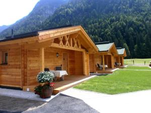 a log cabin with a table on a deck at Austria Parks - Leutasch in Leutasch