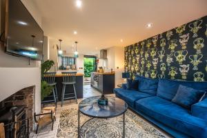 a living room with a blue couch and a kitchen at No 33 Cottage 2 in Thornham