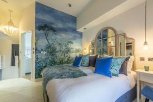 a bedroom with a large bed with a painting on the wall at No 33 Cottage 2 in Thornham