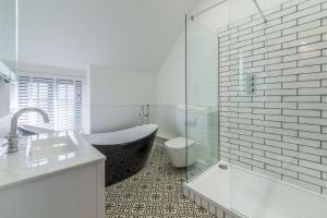 a bathroom with a tub and a toilet and a sink at No 33 Cottage 2 in Thornham +17 photos