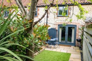 a garden with a house with a blue door at No 33 Cottage 2 in Thornham