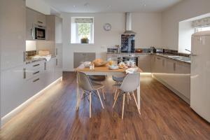 a kitchen with a wooden table and chairs in it at Smiddy in Melrose