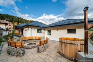 a patio with benches and a fire pit in front of a house at Anais Chalet in Câmpulung Moldovenesc