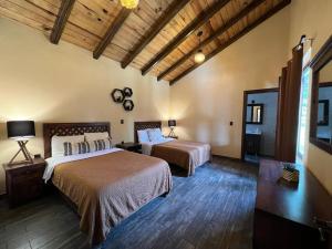 1 Schlafzimmer mit 2 Betten und Holzdecke in der Unterkunft Cabaña No.2 Puerta del Bosque Mazamitla. in Mazamitla