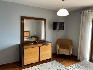 a bedroom with a dresser with a mirror and a chair at Quinta da Penada - Vineyard & Winery - Suíte 3 in Chaves