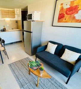 salon z niebieską kanapą i stołem w obiekcie ''Ophélia 84'' Duplex en centre ville avec parking w mieście Sète