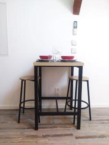 a table with two bowls on it with two stools at Suite Mansardée indépendante, 25min Lyon-Villefranche in Chazay-dʼAzergues