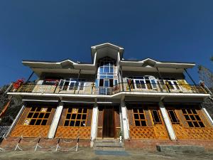 - un grand bâtiment avec un balcon en haut dans l'établissement D’SHIEKHS RESORT GUREZ, à Kanzalwan