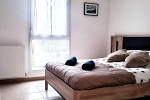 1 dormitorio con 1 cama con 2 almohadas azules en Pour 4 personnes entre Paris et Disneyland., en Pontault-Combault