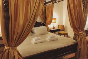 um quarto com uma cama com cortinas e toalhas em Residenza Sinibaldi em Roma