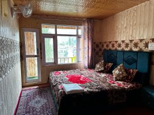Kanzalwan的住宿－D’SHIEKHS RESORT GUREZ，一间带床的卧室,位于带窗户的房间内