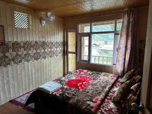 Cama en habitación con ventana en D’SHIEKHS RESORT GUREZ, en Kanzalwan