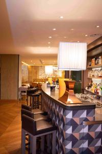 una hall con bar con sedie e lampada di Starhotels Michelangelo Florence a Firenze