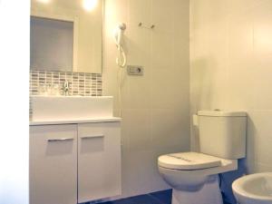 Un baño blanco con inodoro y lavabo. en ALC - San Francisco Javier, en Alicante 7 fotos más