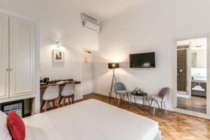 a bedroom with a bed and a desk and chairs at Little Queen Relais in Rome