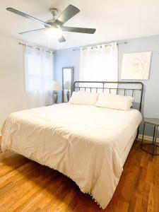a bedroom with a bed with a ceiling fan at Hidden GEM W1 king bed &2 queens in Winston-Salem