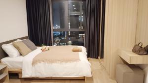 Schlafzimmer mit einem großen Bett und einem Fenster in der Unterkunft Ideo O2 Cozy BTS Bangna in Bangkok