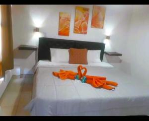 Una cama blanca con una cinta naranja. en Hotel Hacienda Casa Blanca en Tinogasta