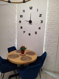 a table with chairs and a clock on a wall at Stara Kamienica przed Fortami in Srebrna Góra