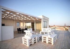 a patio with white tables and chairs on a roof at Keys of Sicily - Marina di Modica in Marina di Modica