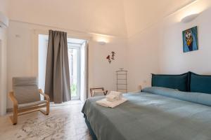 a bedroom with a blue bed and a chair at La Piccola Atrani in Atrani