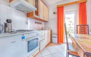 een keuken met een fornuis top oven naast een tafel bij Apartment in Porec - Istrien 45114 in Poreč