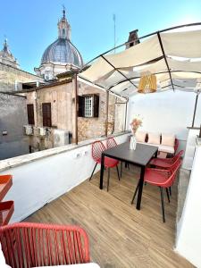 eine Terrasse mit einem Tisch und Stühlen auf dem Dach in der Unterkunft Navona Penthouse - Attico Vista Cupola 4 posti in Rom