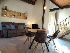 a living room with a table and chairs and a couch at Volaterrae Deluxe Loft with garden in Volterra