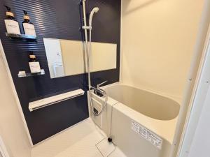 a bathroom with a bath tub and a shower at Neighbor's Hotel 十日市 in Hiroshima