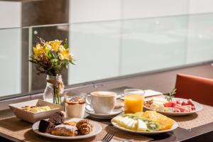 a table topped with plates of breakfast foods and drinks at Hotel Madanis Liceo in Hospitalet de Llobregat