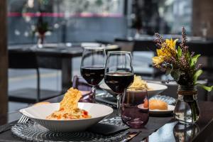 a table with plates of food and glasses of wine at Hotel Madanis Liceo in Hospitalet de Llobregat