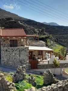 a stone house with a view of a mountain at VILLA CASTELLOS in Priniás