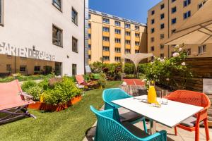 a patio with a table and chairs and buildings at Hotel Zeitgeist Vienna Hauptbahnhof in Vienna