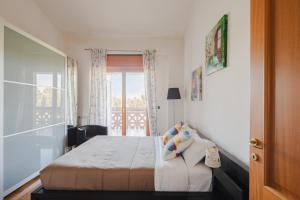 EUR Moravia Attico panoramico con terrazzo, fino a 5 ospiti في روما: غرفة نوم مع سرير ونافذة مع شرفة