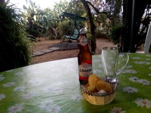 a bottle of beer and a basket of food on a table at B&B Il Vigneto in Capoterra