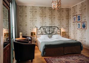 een slaapkamer met een bed, een stoel en een kroonluchter bij Hotell Park in Västervik