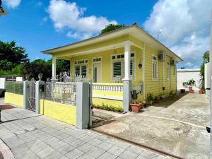 a yellow house with a fence in front of it at New! Antique House at Ponce in Ponce