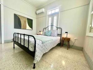 a bedroom with a bed and a window at New! Antique House at Ponce in Ponce