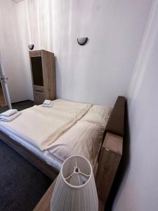 a small bedroom with a bed and a mirror at Apartments Paderewski in Karlovy Vary