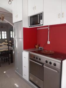 a kitchen with a stainless steel stove and a microwave at Chez Leonilde in São Filipe