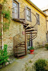 una scala a chiocciola in legno accanto a un edificio di Appart' d'hôtes , ch et gîte au Manoir de la Haute Pilais a Chantepie