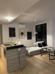 uma cozinha e sala de estar com um sofá e uma mesa em Stylist Apartment Heart of Brossard Dix30 em Brossard