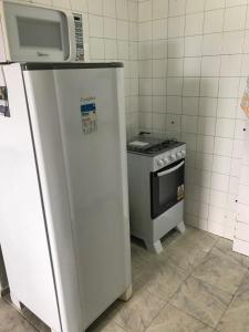 eine kleine Küche mit einem Kühlschrank und einem Herd in der Unterkunft Kitnet 1102 - Apartamento para temporada in Recife