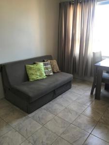 ein Sofa mit zwei Kissen darauf im Wohnzimmer in der Unterkunft Kitnet 1102 - Apartamento para temporada in Recife