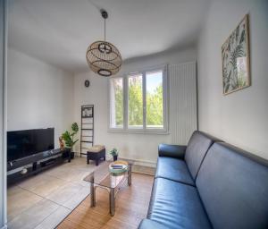 ein Wohnzimmer mit einem blauen Sofa und einem TV in der Unterkunft Le théatre du Cours in Grenoble
